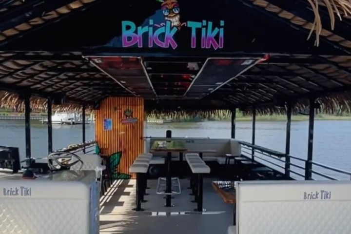 Tiki-style boat with bar seating, open to a river view, labeled 'Brick Tiki'.