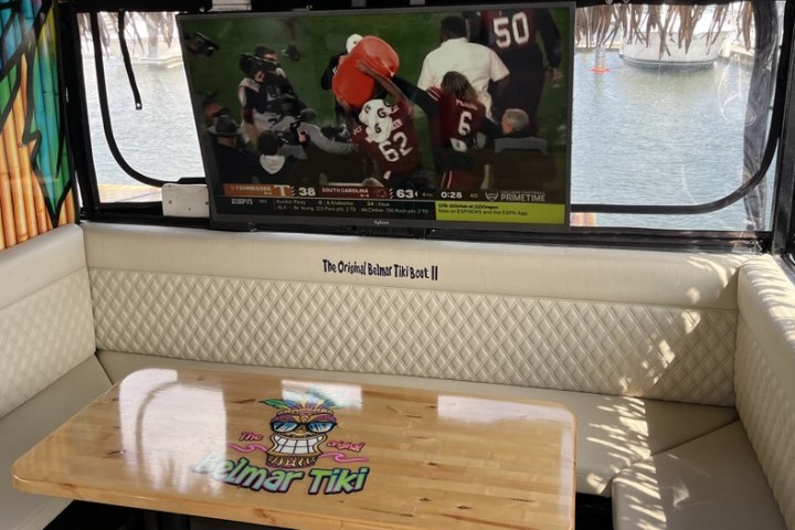 Tiki boat interior with a TV showing a football game and a table with a colorful design.